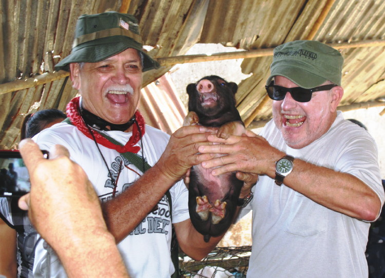 Vietnam Battlefield Tours, visit to Bru Montagnard Village with a basket of five young pigs purchased at a local market Vietnam Battlefield Tours, visit to Bru Montagnard Village with a basket of five young pigs purchased at a local market