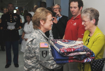 Maria Fox-Meehan receives a handmade quilt of valor during the dedication ceremony of The Thomas Meehan Suite Maria Fox-Meehan receives a handmade quilt of valor during the dedication ceremony of The Thomas Meehan Suite